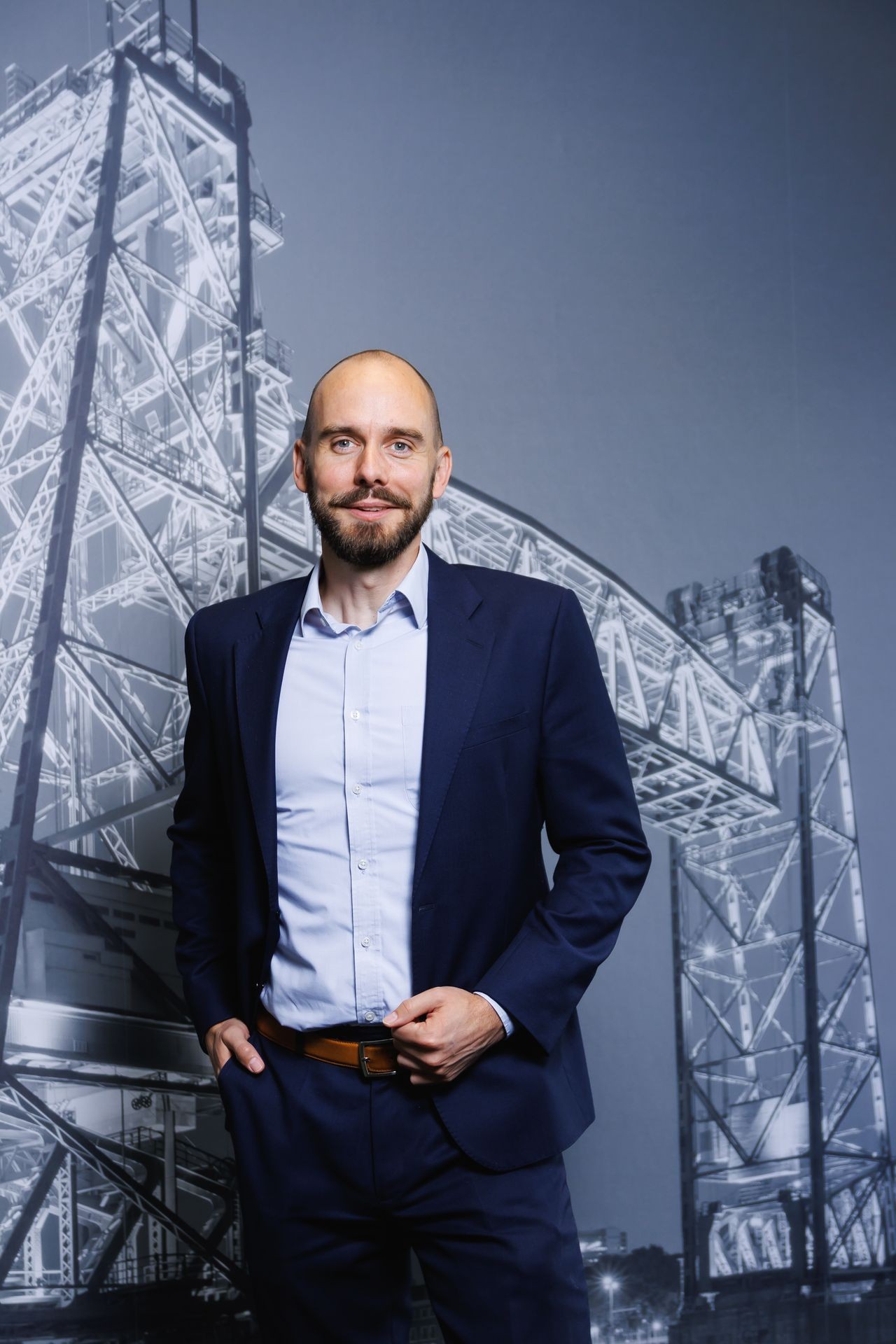 Medewerker van Publieke Sector Accountants professioneel geportretteerd voor de houten PSA-achterwand.